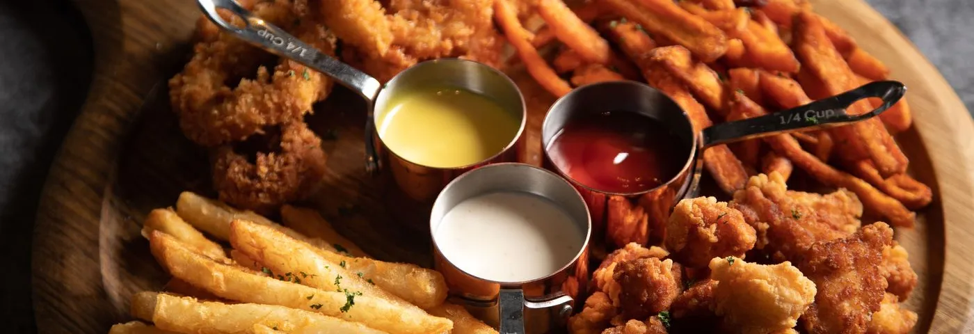 Wingstop menu: a tray of fried chicken wings, fries and dipping sauces